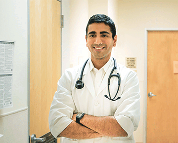 Asian doctor standing with arms crossed.