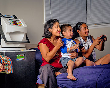 DaVita home dialysis patient at home watching her children play video games