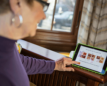 Woman looking right at tablet.