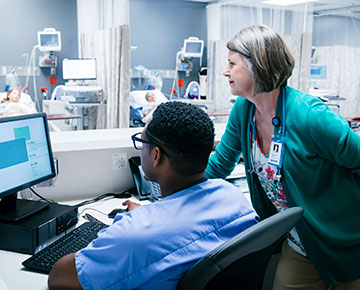 Physician and nurse looking at computer
