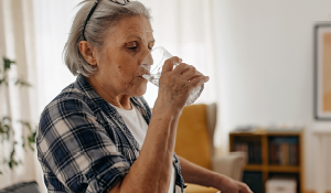 Elderly woman drinking water.