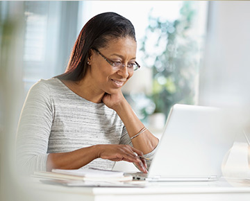 Woman sitting at desk looking at a laptop computer